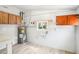 Storage area features light tile flooring, water heater, window, and upper wood cabinets at 2604 Oakdale St, Seffner, FL 33584