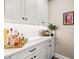 This butler's pantry features elegant white cabinets, quartz countertops, and wine storage at 2644 Leafwing Ct, Palm Harbor, FL 34683