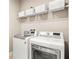 Functional laundry room with modern, front-loading washer and dryer, plus wire shelving for storage at 2644 Leafwing Ct, Palm Harbor, FL 34683