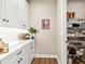 Butler's pantry featuring white cabinets, wine rack and a walk in pantry with wire shelving at 2644 Leafwing Ct, Palm Harbor, FL 34683