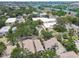 An aerial view highlights townhomes near businesses, with lush trees lining the landscape and city buildings in the distance at 310 S Delaware Ave # F, Tampa, FL 33606