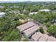 An aerial view of a townhome complex nestled among lush greenery and palm trees, with a city skyline in the distance at 310 S Delaware Ave # F, Tampa, FL 33606