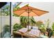 Charming outdoor dining area with a patio umbrella surrounded by lush greenery at 310 S Delaware Ave # F, Tampa, FL 33606