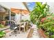 Serene outdoor space with lush greenery, a dining table under an umbrella, and a stone walkway at 310 S Delaware Ave # F, Tampa, FL 33606