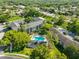 Aerial shot of condo complex with pool, surrounded by lush landscaping and trees at 330 Promenade Dr # 206, Dunedin, FL 34698