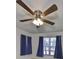 Bedroom showcases a modern ceiling fan and natural light from the window with curtains at 330 Promenade Dr # 206, Dunedin, FL 34698