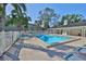 A refreshing community pool area surrounded by lush palm trees and comfortable lounge chairs under a clear blue sky at 330 Promenade Dr # 206, Dunedin, FL 34698