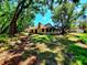 Expansive backyard with mature trees, a brick firepit, and ample space for recreation at 3529 Tanglewood Trl, Palm Harbor, FL 34685