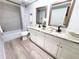 Bathroom featuring double sinks, granite countertop, and modern fixtures at 3529 Tanglewood Trl, Palm Harbor, FL 34685
