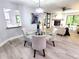 Dining area with a modern chandelier, glass table, and comfortable seating at 3529 Tanglewood Trl, Palm Harbor, FL 34685