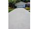 Long, paved driveway leading to a two-car garage, surrounded by green lawns and mature trees at 3529 Tanglewood Trl, Palm Harbor, FL 34685