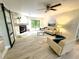 Bright living room featuring stone fireplace, modern furnishings, ceiling fan, and view to outside at 3529 Tanglewood Trl, Palm Harbor, FL 34685