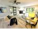 Bright living room featuring stone fireplace, modern furnishings, ceiling fan, and sliding barn door at 3529 Tanglewood Trl, Palm Harbor, FL 34685