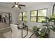 Home office with large windows overlooking a yard and an open view to the kitchen at 3529 Tanglewood Trl, Palm Harbor, FL 34685