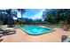 Community pool with lounge chairs and a privacy fence on a sunny day at 3529 Tanglewood Trl, Palm Harbor, FL 34685