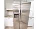 Close up of stainless steel refrigerator and white cabinets with granite countertops at 3529 Tanglewood Trl, Palm Harbor, FL 34685
