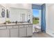 Well-lit bathroom featuring a double vanity, framed mirror, stylish blue decor, and a refreshing window view at 35896 Sunflower Hill Dr, Zephyrhills, FL 33541