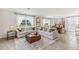 Bright living room showcasing neutral decor, large windows with backyard view, and an open floor plan at 35896 Sunflower Hill Dr, Zephyrhills, FL 33541