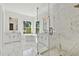 Bright bathroom featuring marble floors, modern double vanity, soaking tub and glass enclosed shower at 3905 W San Obispo St, Tampa, FL 33629