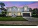 Charming two-story home featuring white siding, manicured lawn, and a beautiful, colorful sunset backdrop at 3905 W San Obispo St, Tampa, FL 33629