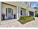 Inviting front porch adorned with seasonal flower pots, a stylish front door wreath, and a charming walkway at 3905 W San Obispo St, Tampa, FL 33629