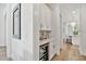 Hallway with beverage cooler and cabinetry, leading to kitchen and dining areas at 3905 W San Obispo St, Tampa, FL 33629