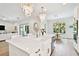 Bright, white kitchen with a farmhouse sink, marble countertops, and modern chandeliers at 3905 W San Obispo St, Tampa, FL 33629