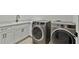 Bright laundry room with front load washer and dryer set and white cabinetry at 3905 W San Obispo St, Tampa, FL 33629