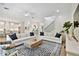 Large open living space featuring hardwood floors, white sofas, view to kitchen, and a stylish area rug at 3905 W San Obispo St, Tampa, FL 33629