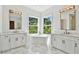 A luxurious bathroom features double sinks, a standalone tub, and bright natural light at 3905 W San Obispo St, Tampa, FL 33629