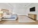 Light and bright main bedroom with wood flooring, tray ceiling, and a wall-mounted TV at 3905 W San Obispo St, Tampa, FL 33629