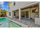 Covered patio has an outdoor kitchen, dining area, and overlooks the backyard pool at 3905 W San Obispo St, Tampa, FL 33629