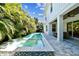 Relaxing backyard pool with tropical foliage and covered outdoor seating area at 3905 W San Obispo St, Tampa, FL 33629