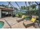 Screened-in pool area with lounge chairs and grill, perfect for relaxation and outdoor gatherings at 40 Pine Lake Dr, Oldsmar, FL 34677