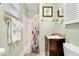 Well-lit bathroom with walk-in shower, vanity with granite countertop, and coastal decor at 412 80Th St, Holmes Beach, FL 34217