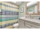 Cozy bathroom featuring modern vanity with marble countertops and a shower with patterned curtain at 412 80Th St, Holmes Beach, FL 34217