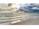 Stunning beach featuring calm ocean waves under a dramatic cloudy sky at 412 80Th St, Holmes Beach, FL 34217