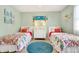 Bright bedroom with two twin beds, light wood floors, coastal decor, and white dresser at 412 80Th St, Holmes Beach, FL 34217