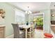 Bright dining area with a table for six, chandelier lighting, and access to an outdoor deck at 412 80Th St, Holmes Beach, FL 34217