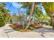 Expansive front yard with lush tropical landscaping enhances the curb appeal of this delightful beach home at 412 80Th St, Holmes Beach, FL 34217