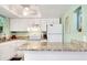 Bright kitchen features granite countertops, white cabinetry, and modern appliances at 412 80Th St, Holmes Beach, FL 34217