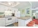 Bright kitchen with modern appliances and granite countertops, adjacent to a living area at 412 80Th St, Holmes Beach, FL 34217