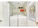 Functional laundry room with washer, dryer, storage shelves, and natural light at 412 80Th St, Holmes Beach, FL 34217