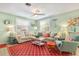Bright living room with coastal-themed decor, comfortable seating, and an eye-catching red patterned rug at 412 80Th St, Holmes Beach, FL 34217