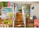 Inviting wooden stairs lead to a charming beach house, surrounded by lush tropical foliage at 412 80Th St, Holmes Beach, FL 34217