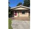 Exterior of a home featuring a red door, stone walkway, and charming architectural details around the window at 4218 Carson Ne St, St Petersburg, FL 33703
