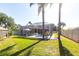 Lush backyard with a screened-in pool area, mature trees, and a well-maintained lawn at 4822 Hamlets Grove Dr, Sarasota, FL 34235