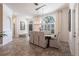 Inviting dining area with large arched window and stylish decor with a view of the entry and front yard at 4822 Hamlets Grove Dr, Sarasota, FL 34235
