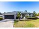 Charming single-story home with lush landscaping, brick driveway, and a two-car garage at 4822 Hamlets Grove Dr, Sarasota, FL 34235