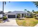 Charming single-story home with a well-maintained lawn, brick driveway, and a two-car garage at 4822 Hamlets Grove Dr, Sarasota, FL 34235